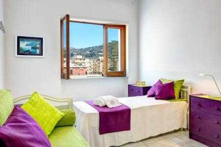 una camera da letto con un letto con cuscini viola e verdi di Skyline Sorrento Views in the heart of Sorrento a Sorrento