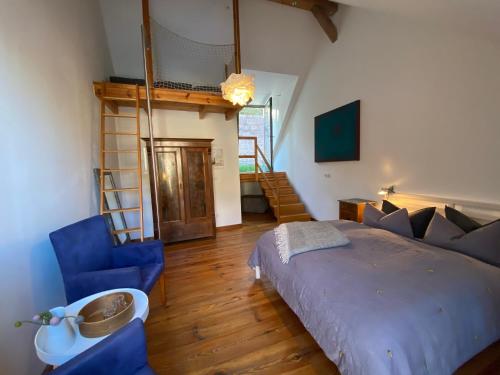 a bedroom with a bed and blue chairs in a room at Gasthof zum grünen Baum in Boitzenburg