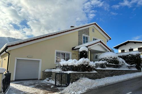 a snow covered house with a garage at Luxury-Suites Traunsee in Traunkirchen