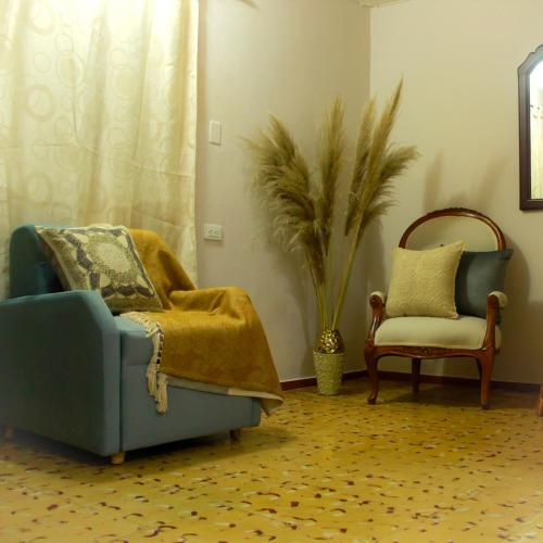 sala de estar con sofá azul y silla en Casa Mostaza, en Medellín