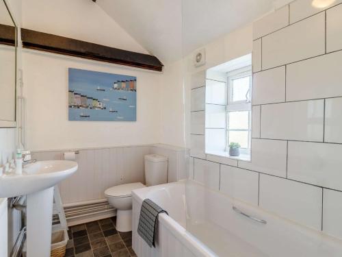 y baño con bañera, aseo y lavamanos. en 1 bed in Wroxham 87414 en Hainford