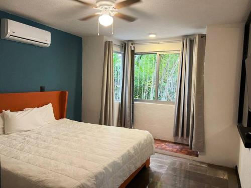 a bedroom with a bed and a large window at Espacioso, Centrico, Acogedor y Buena Ubicacion in Cancún