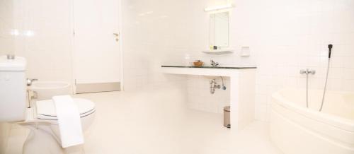 a white bathroom with a toilet and a sink at Ibri Oasis Hotel in Ibri