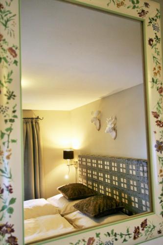 a mirror above a bed in a bedroom at Das Schmiedhaus in Kaprun