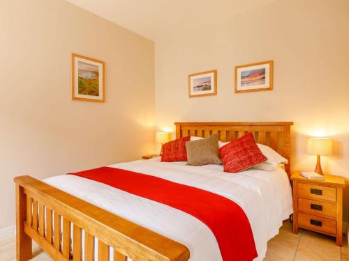 a bedroom with a wooden bed with red pillows at 1 Bed in South Molton 89089 in South Molton