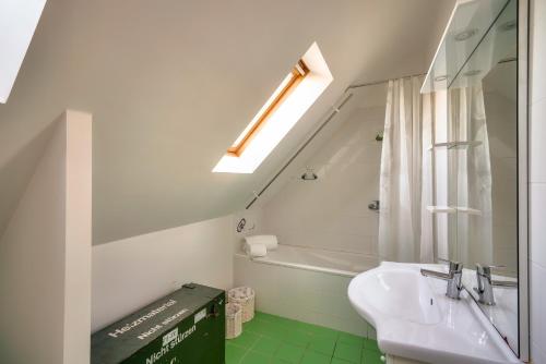 une salle de bain avec un lavabo et une baignoire dans l'établissement Vue mer à Penmarch - Maison pour 4, à Penmarcʼh