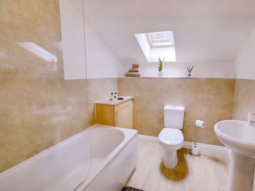a bathroom with a tub and a toilet and a sink at 1 Bed in Holmfirth 88554 in Holmfirth