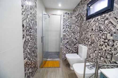 ein Bad mit WC und ein TV an der Wand in der Unterkunft RentitSpain Las Fanegas Montañas de Alpujarra in Yátor
