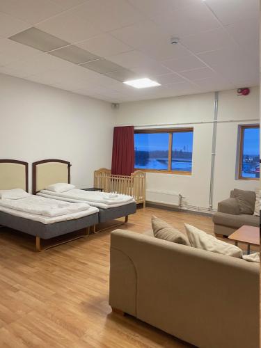 Zimmer mit 2 Betten und einem Sofa in der Unterkunft Trestads Värdshus in Vänersborg