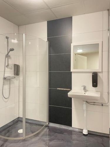 a bathroom with a shower and a sink at Trestads Värdshus in Vänersborg