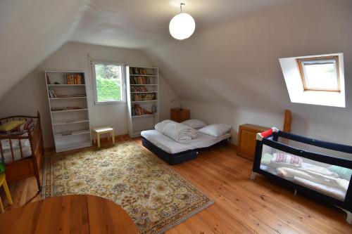 een zolderkamer met een bed en een boekenplank bij Vacances familiales a Erquy in Erquy