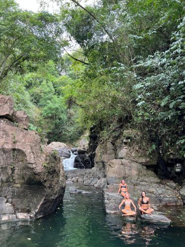 a group of people in the water near a waterfall at Hostal La Casa de Juan in Valle de Anton