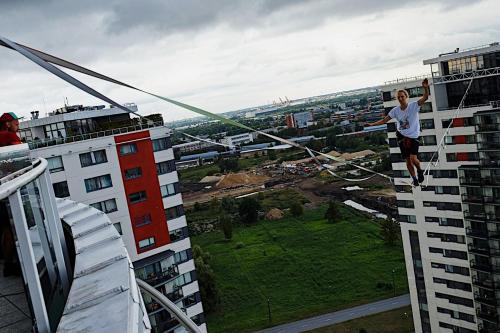 a man is jumping off the side of a building at Skanstes Virsotnes Flying Bed Apartment (Skanstes Heights) in Riga