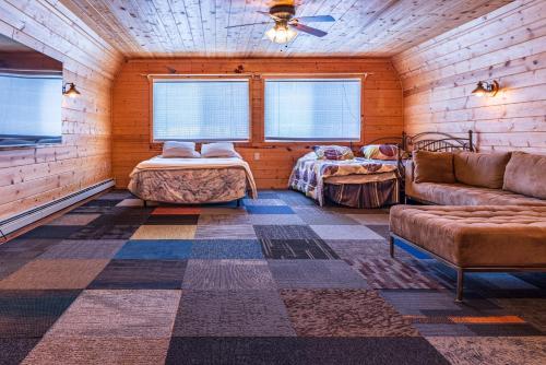 ein Wohnzimmer mit einem Sofa und einem Bett in einem Zimmer in der Unterkunft Lake Manistee Lodge Ski & Snowmobile Hideout in Kalkaska