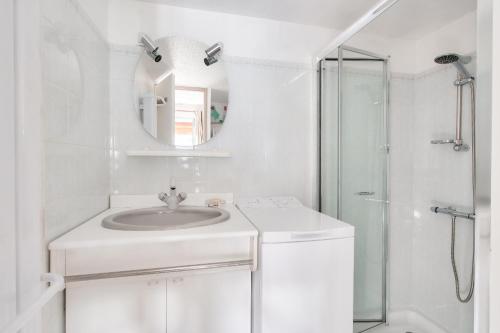 une salle de bain blanche avec un lavabo et une douche dans l'établissement Résidence vacances avec piscine- maison pour 4, à Saint-Vincent-sur-Jard