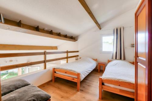 une chambre avec deux lits et une fenêtre dans l'établissement Résidence vacances avec piscine- maison pour 4, à Saint-Vincent-sur-Jard