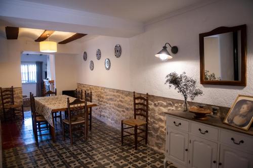 uma sala de jantar com uma mesa, cadeiras e um espelho em CASA LOLA Naturaleza, Montañas y Piscina Compartida De Pueblo em Carroja