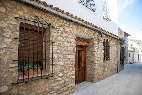 um edifício de pedra com uma porta e uma janela em CASA LOLA Naturaleza, Montañas y Piscina Compartida De Pueblo em Carroja