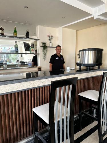 a man standing at a bar in a restaurant at Elaria Hotel Hurgada in Hurghada