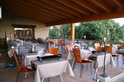 ein Restaurant mit Tischen und Stühlen mit weißem Tischtuch in der Unterkunft Hotel Villaro Del Bosc in Freixinet