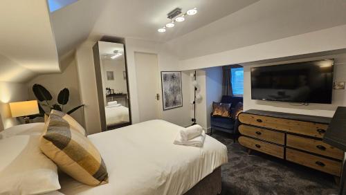 a bedroom with a large bed and a television at ABBEY HOTEL in Stafford