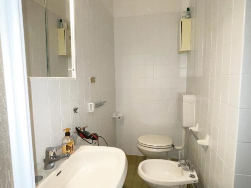 Łazienka z białą toaletą i umywalką w obiekcie Piscina e Posto Auto per un Relax a 400 mt dal mare w mieście Pietra Ligure