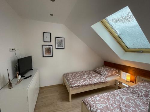 a bedroom with a bed and a desk and a window at Auszeit im Wald - mit Schwimmbad! 