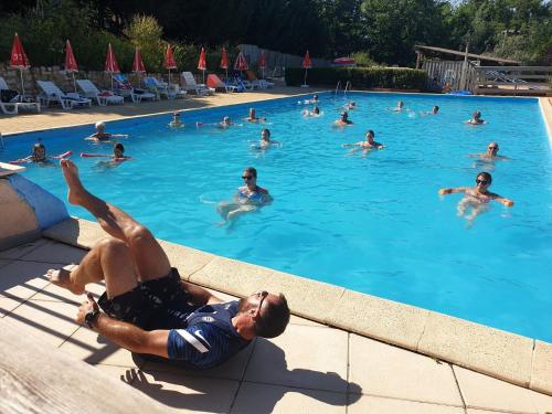 un grupo de personas nadando en una piscina en Camping des Bastides, en Salles