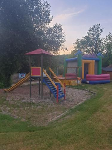 une aire de jeux avec un toboggan et une structure de jeu dans l'établissement Camping des Bastides, à Salles