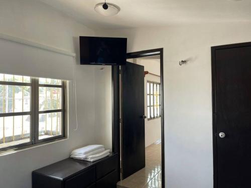 カンクンにあるEspaciosa,Centrica y bonita casa, 10 personasの壁にテレビと鏡が備わる部屋