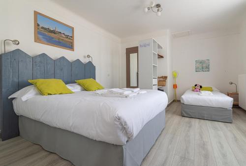 um quarto com 2 camas grandes e almofadas amarelas em Hotel Esperanza em Noirmoutier-en-l'lle