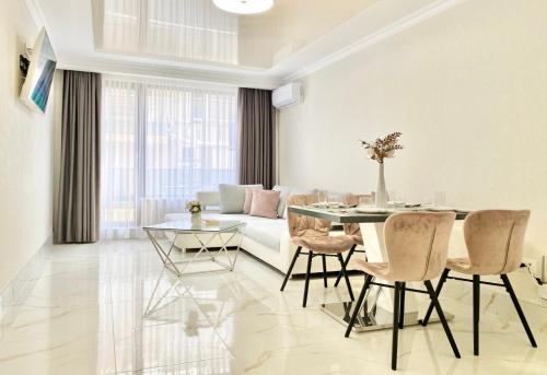 a dining room with a table and chairs and a couch at Modern Apartment for 4 Guests Sea View & Free Parking in Pomorie