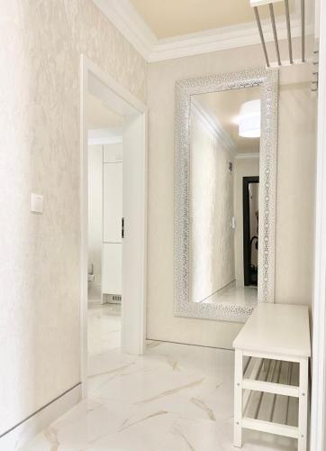 a mirror in a white room with a white stool at Modern Apartment for 4 Guests Sea View & Free Parking in Pomorie