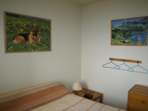 sypialnia z łóżkiem i obrazem psa w obiekcie Appartement Les Adrets-Prapoutel, 2 pièces, 6 personnes - FR-1-557-69 w mieście Les Adrets