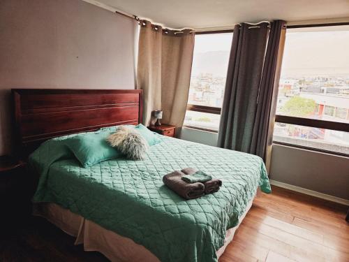 1 dormitorio con 1 cama con manta verde y ventana en 1 dormitorio 1 baño dpto en Iquique, en Iquique