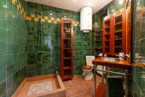 a green tiled bathroom with a shower and a sink at Central Park Apartments in Belgrade