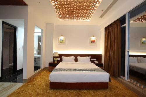 a bedroom with a large bed and a bathroom at Empyrean Dhaka City Centre in Dhaka
