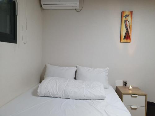 a bedroom with a white bed with a white comforter at 29 Play House in Incheon