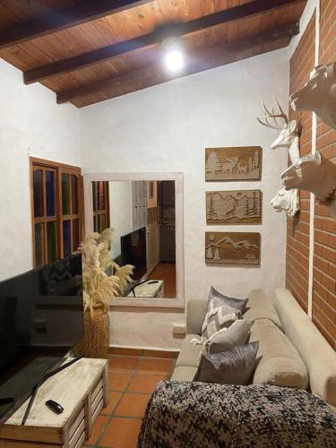 a living room with a couch and a tv at Cabaña campestre en la Ceja in La Ceja