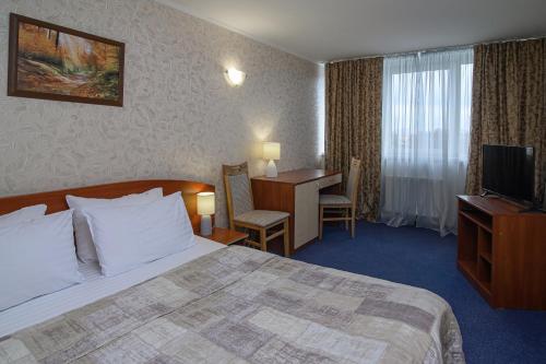 ein Hotelzimmer mit einem Bett und einem Schreibtisch in der Unterkunft Cherkasy Palace in Tscherkassy