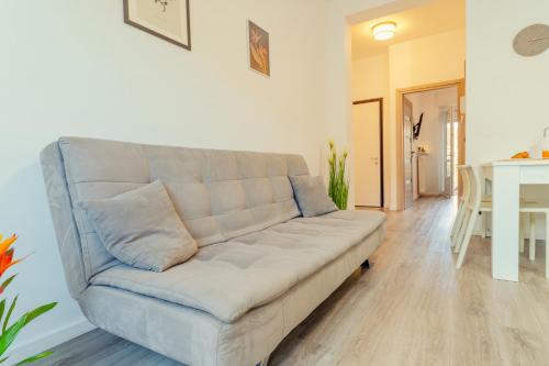 a white couch in a living room with a table at BnB Il Bicciolano in Vercelli