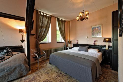 a bedroom with two beds and a chandelier at Mare Sanat in Wijk aan Zee
