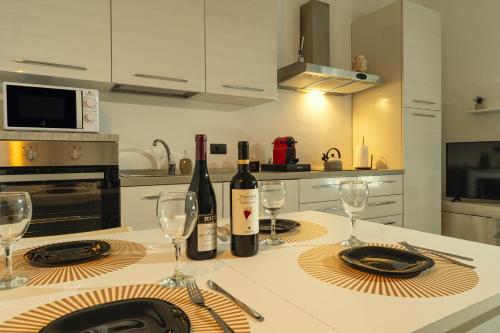 una cocina con una mesa con botellas de vino y copas en BnB Il Bicciolano, en Vercelli