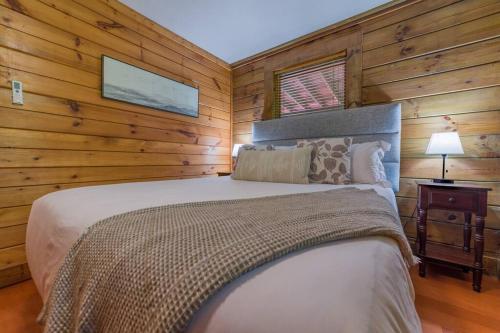 1 dormitorio con 1 cama grande en una cabaña de madera en Couples Getaway Cabin near National Park w Hot Tub en Pigeon Forge