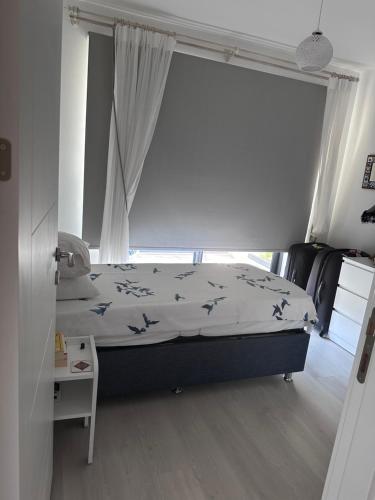 a bedroom with a bed and a window at Q2 Çiçek sitesi in Bodrum City