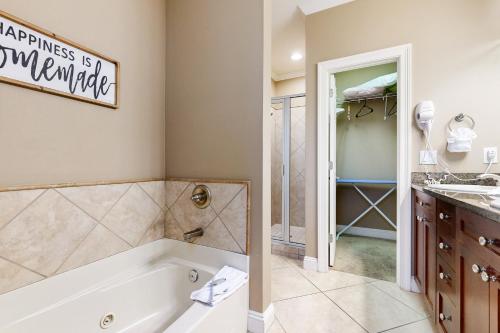 a bathroom with a tub and a walk in shower at Villages of Crystal Beach: Serenity in Destin