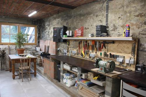 a workshop with a table and tools on the wall at L'ARONDE in Olloy-sur-Viroin