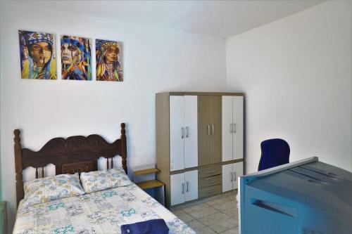 ein Schlafzimmer mit einem Bett, einer Kommode und einem TV in der Unterkunft Casa Central em Pará de Minas in Pará de Minas