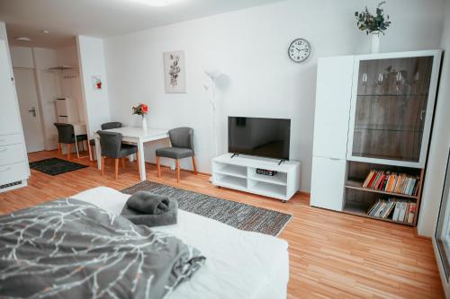 sala de estar con cama, TV y mesa en Vienna Danube Apartment 45, en Viena