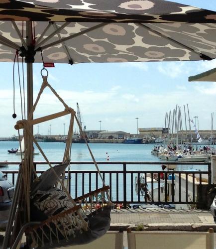 a chair under an umbrella next to a body of water at Casa Mariuccia in Anzio